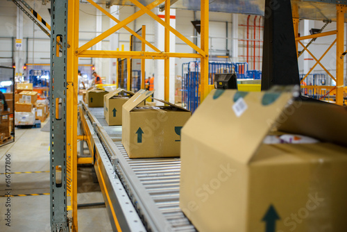 conveyor belt in the delivery warehouse, with packing cartons in the foreground