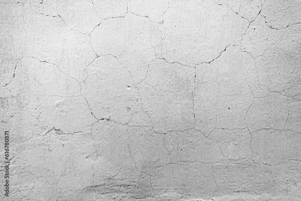 A weathered concrete wall with cracked texture in black and white.