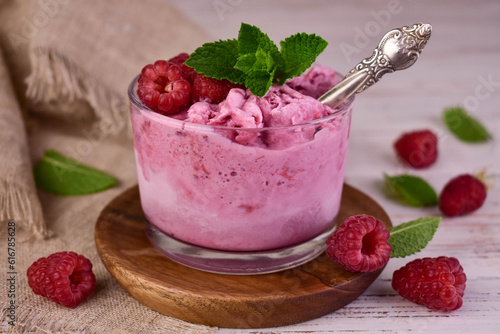 Raspberry ice cream in a glass with fresh raspberries. Close-up.
