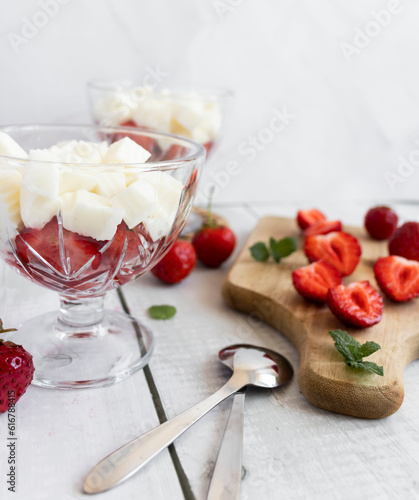  Strawberry dessert with whipped cream and fresh strawberries. On a white wooden background