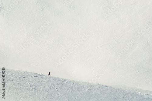 A skier traversing a ridge in front of an empty snowfield on Mount Superior, Uinta-Wasatch-Cache National Forest in Salt Lake County, Utah photo