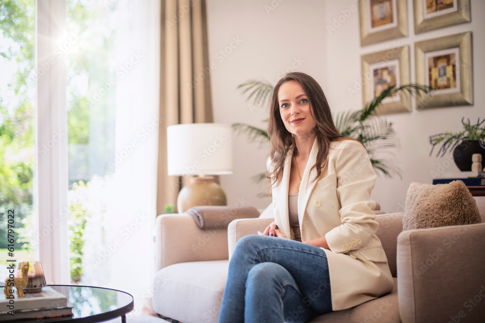 Portrait of brunette haired young woman relaxing in an armchair at the modern home Portrait of brunette haired young woman relaxing in an armchair at the modern home