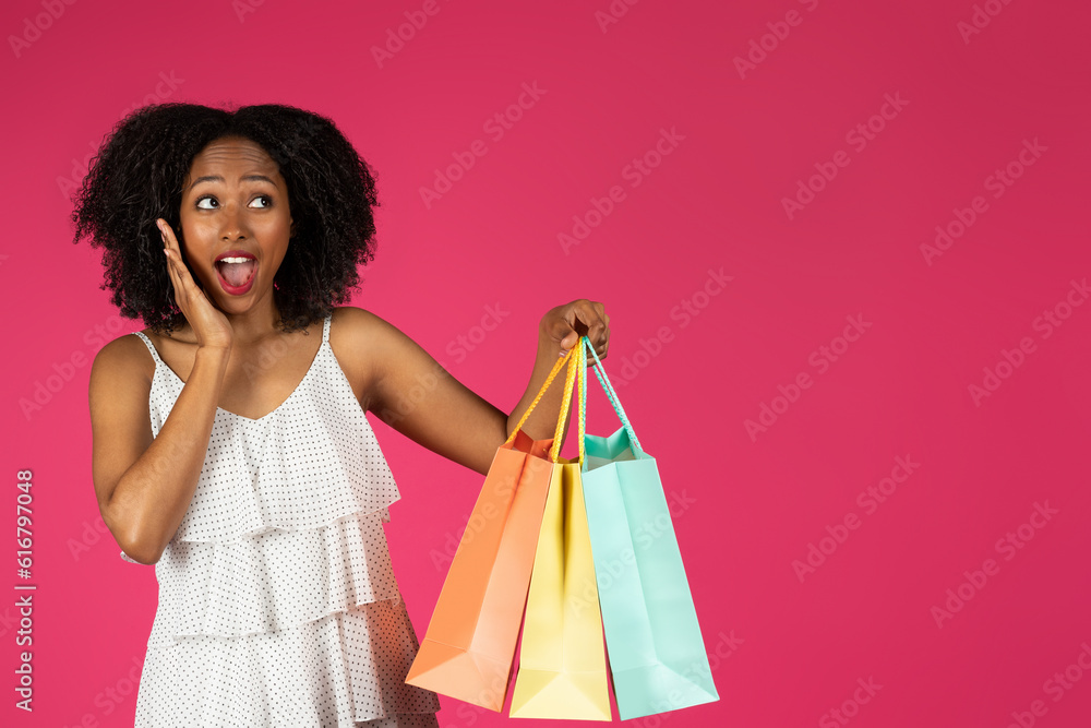 Smiling shocked millennial black lady with open mouth show many packages with purchases Smiling shocked millennial black lady with open mouth show many packages with purchases