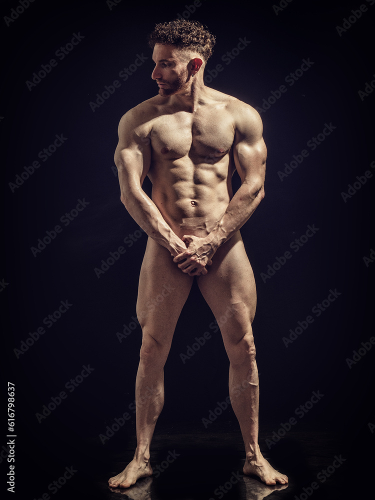 Portrait of naked handsome man covering crotch
