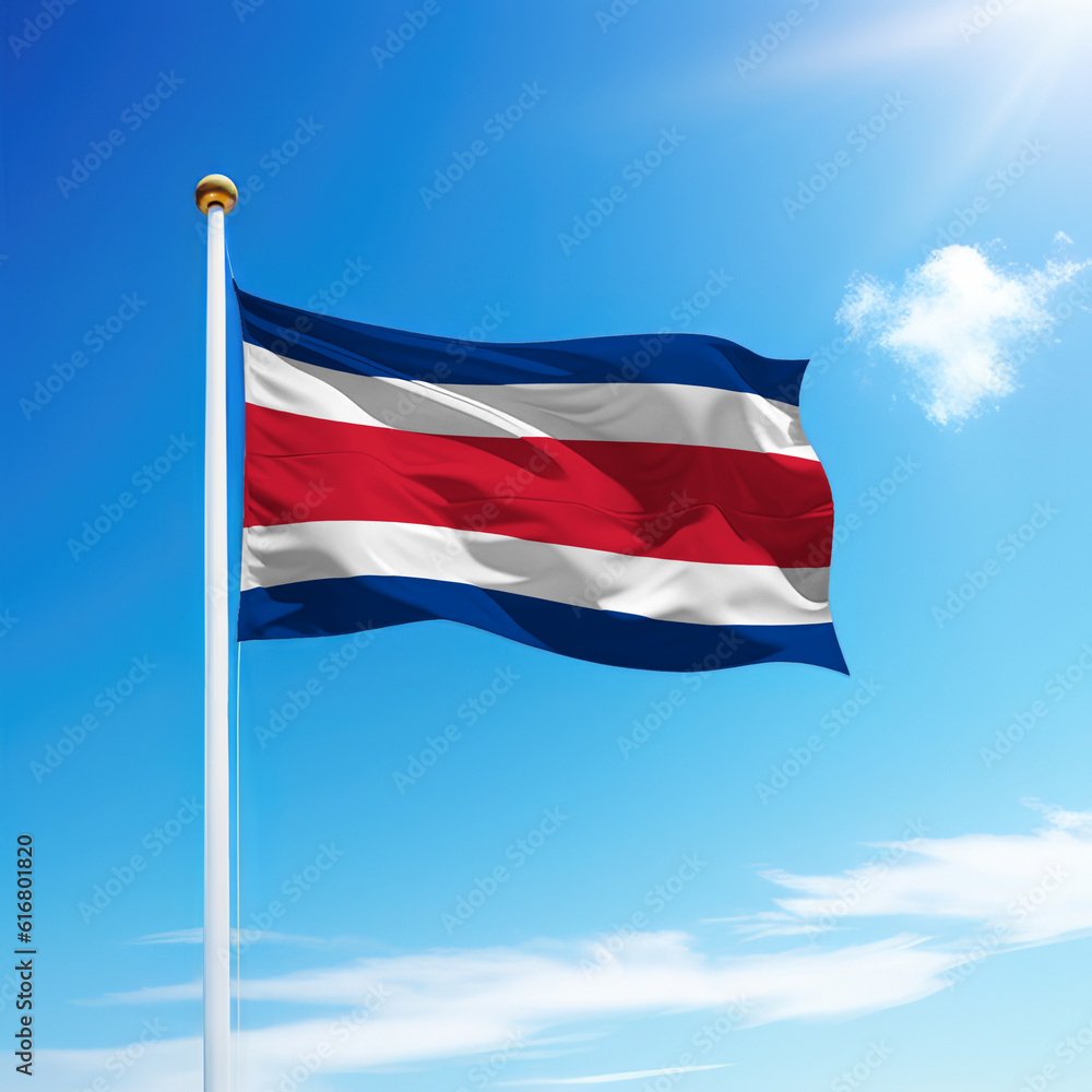 Naklejka premium Waving flag of Costa Rica on flagpole with sky background.