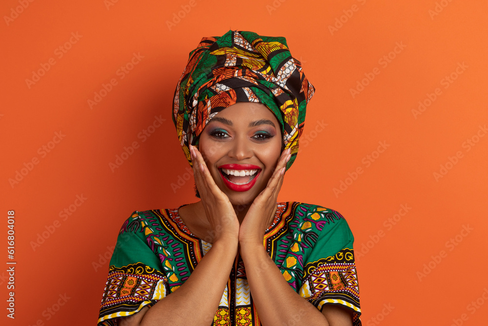 Surprised young black lady showing amazement on orange