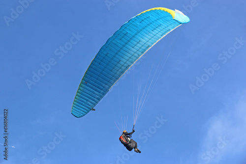 Paraglider flying in a blue sky	