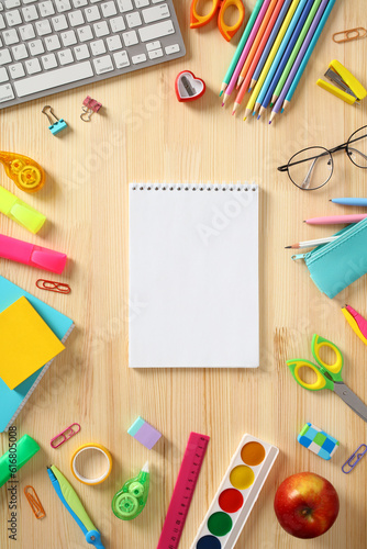 School stationery and blank paper notebook on wooden table. Back to school concept. Flat lay, top view.