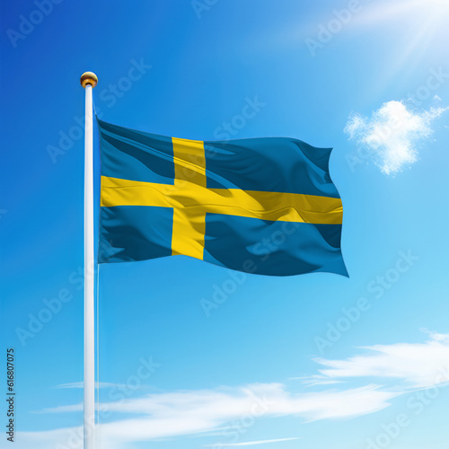 Waving flag of Sweden on flagpole with sky background.
