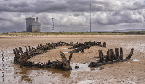 Remains of wooden fishing boat embedded in sand on Teeside