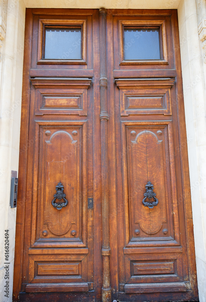 Old ornate door in Paris - typical old apartment buildiing. Old ornate door in Paris - typical old apartment buildiing.