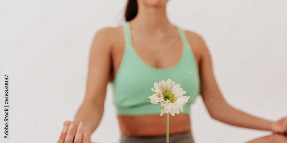 Flour with woman and yoga class in the background. Yoga and mind. Health and body wellness concept. Skin relaxation and treatment. Flour with woman and yoga class in the background. Yoga and mind. Health and body wellness concept. Skin relaxation and treatment.