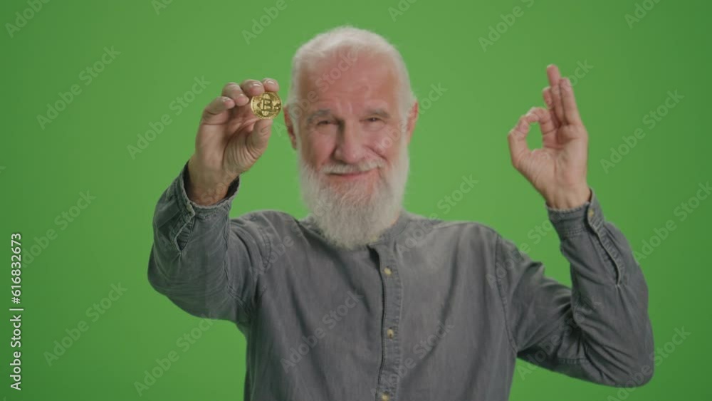 Green Screen. Portrait of a Smiling Old Man with BTC Coin Shows Thumb Up. Achievement Career Wealth, Cryptocurrency Investment, Mining. Cryptocurrency for Older Generations. Green Screen. Portrait of a Smiling Old Man with BTC Coin Shows Thumb Up. Achievement Career Wealth, Cryptocurrency Investment, Mining. Cryptocurrency for Older Generations.