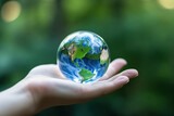 Photo of a hand holding a glass globe, symbolizing the importance of recycling