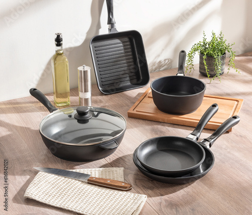 An array of cookware of pots and pans on a rustic wooden table