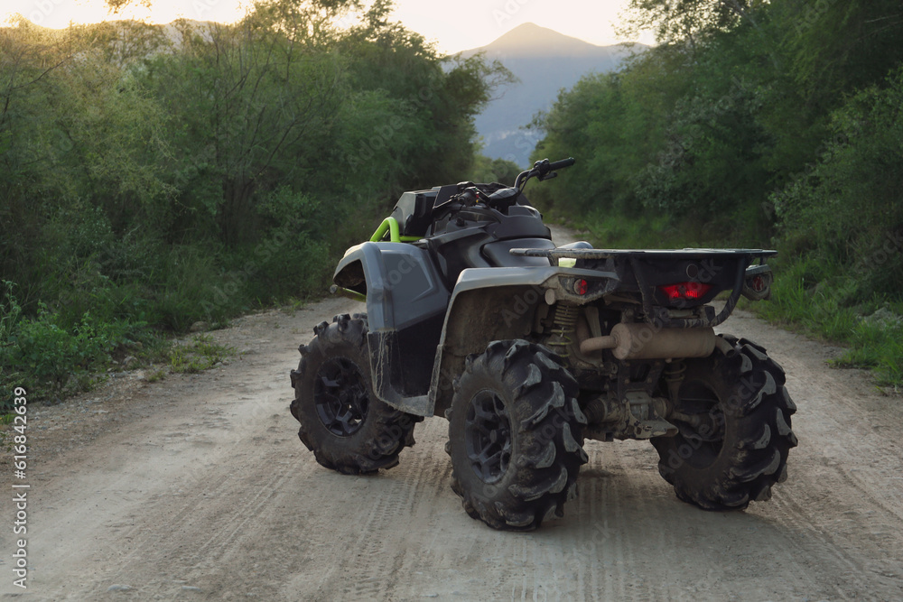 Modern fast quad bike on pathway outdoors Modern fast quad bike on pathway outdoors