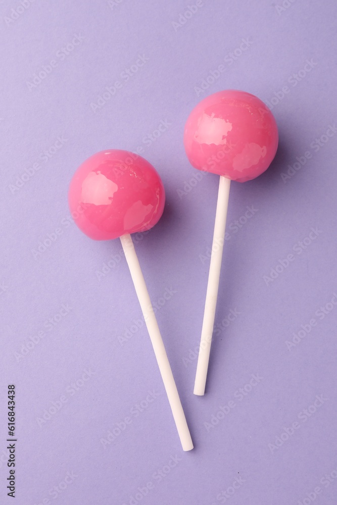 Tasty lollipops on violet background, flat lay Tasty lollipops on violet background, flat lay