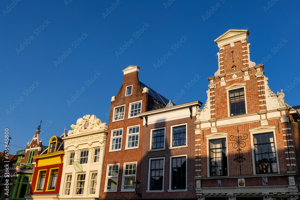 Typical Dutch style houses at Hoorn city in Netherlands against blue sky.