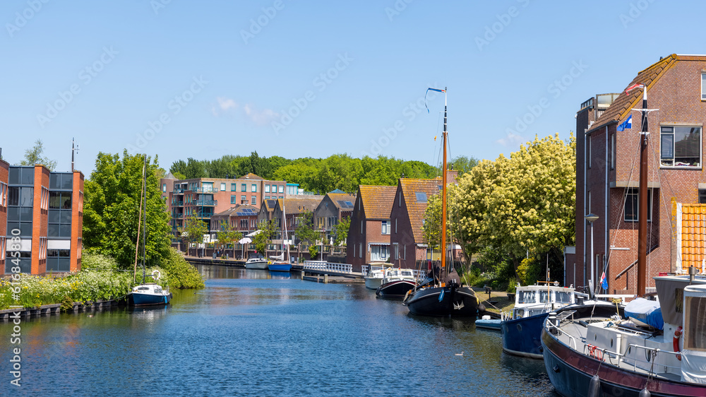 Obraz premium Scenic view of historic Enkhuizen city with canal and Dutch homes in The Netherlands.