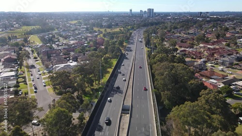 Aerial drone view above the South Western M5 Motorway at Casula in Sydney, NSW Australia with Liverpool CBD in the background 