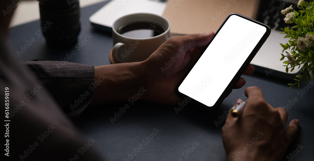 Man hands holding smart phone with blank screen for your text message or information content.