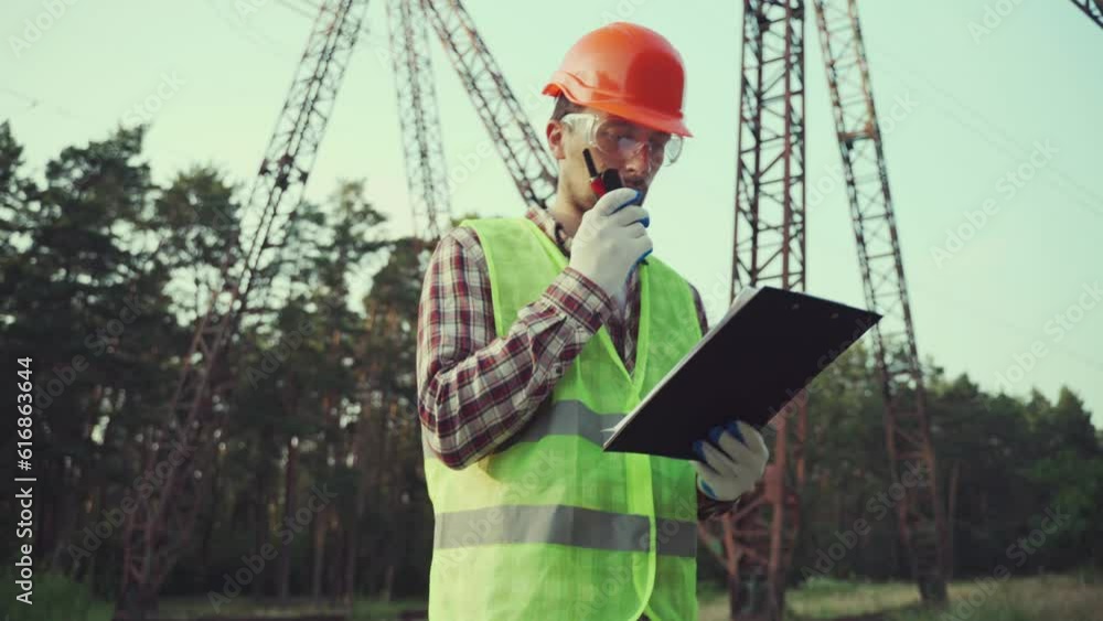 Electrical engineer wearing hard hat and safety vest checking