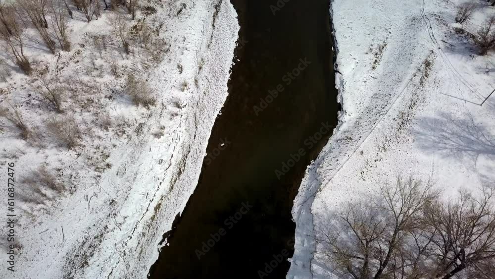 Aerial Tilt Up Shot Of River Amidst Snow And Bare Trees Against Sky, Drone Flying Over Natural Landscape - Billings, Montana Aerial Tilt Up Shot Of River Amidst Snow And Bare Trees Against Sky, Drone Flying Over Natural Landscape - Billings, Montana