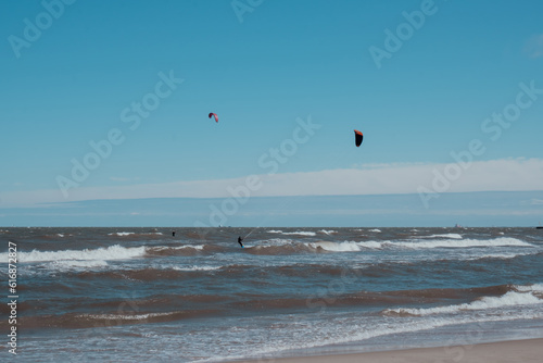 Wing Foiling kitesurfing wind surfing water outdoor sport in Baltic sea Dark blue clouds ocean water surface with foam waves before storm, dramatic seascape background. 