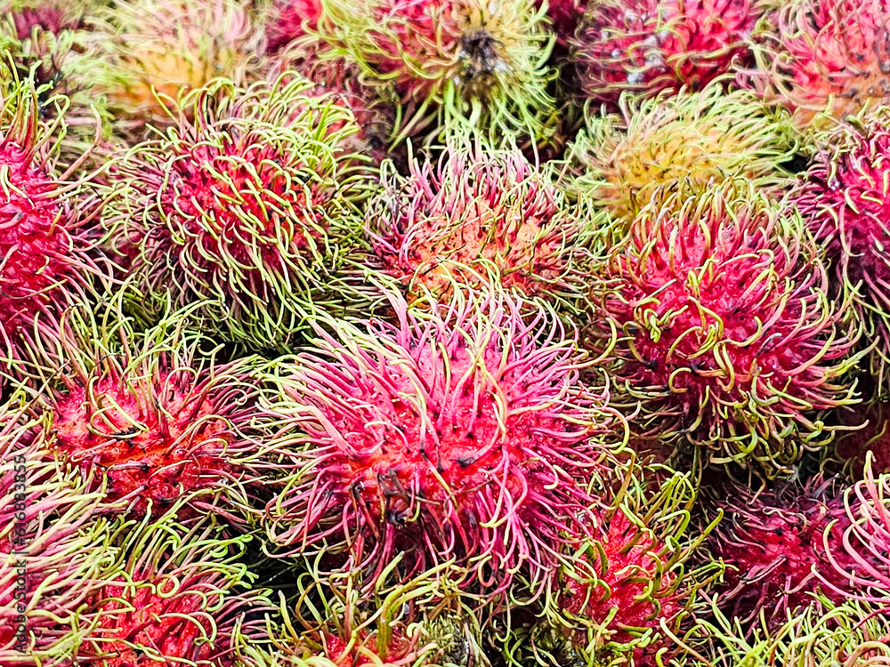 Close-up Fresh of Rambutan Thai fruit. Organic Rambutan pile from local agriculture farm. The pile of Rambutan at the market in Thailand. Rambutan background. Close-up Fresh of Rambutan Thai fruit. Organic Rambutan pile from local agriculture farm. The pile of Rambutan at the market in Thailand. Rambutan background.