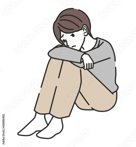 落ち込む体育座りの女性