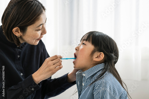 子供の歯磨きをする母親