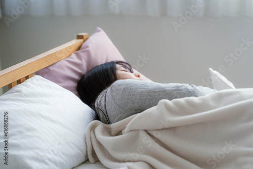 ベッドに横になる若い日本人女性
