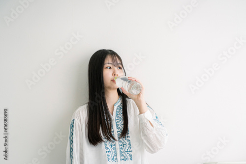 ペットボトルのミネラルウォーターを飲む若い日本人女性 photo