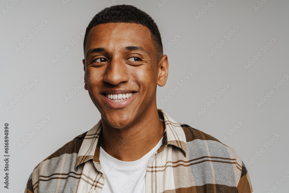 Young brunette man in shirt looking aside and smiling at camera Young brunette man in shirt looking aside and smiling at camera