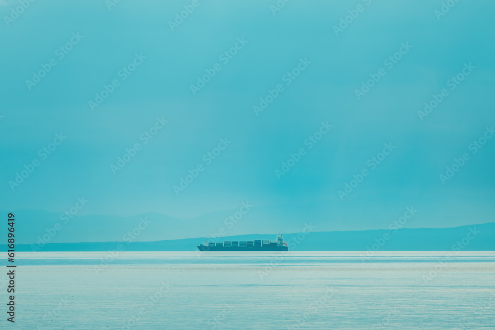 Large container ship sailing at sea in overcast morning