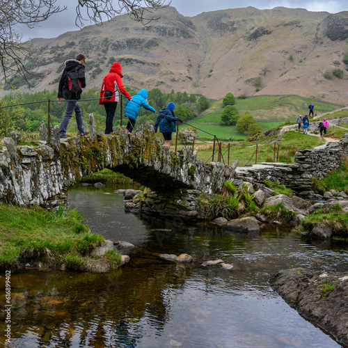 Walkers crossing a packhorse bridge in the Lake District