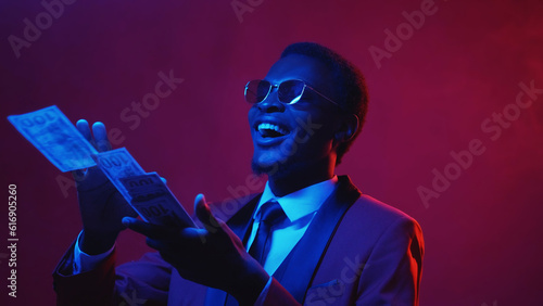 Millionaire money. Rich people lifestyle. Blue pink color neon light amused happy smiling business man enjoying spending throwing away dollar cash on dark empty space.