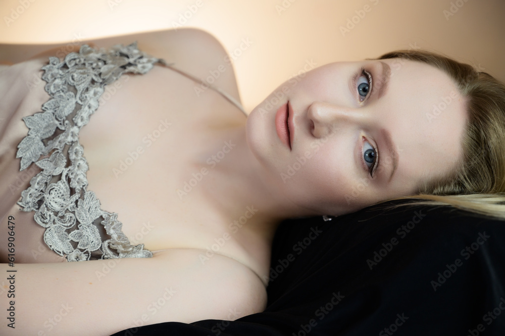 Naklejka premium Calm young woman with blue eyes on pillow.