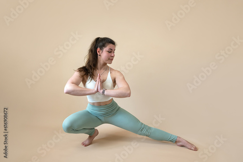 Sporty young woman doing yoga meditation exercise isolated on white © RomanR