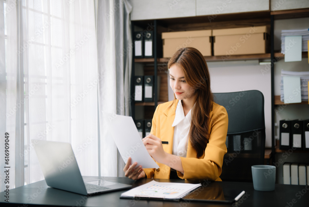 Young beautiful woman typing on tablet and laptop while sitting at the working wooden table office. Young beautiful woman typing on tablet and laptop while sitting at the working wooden table office.