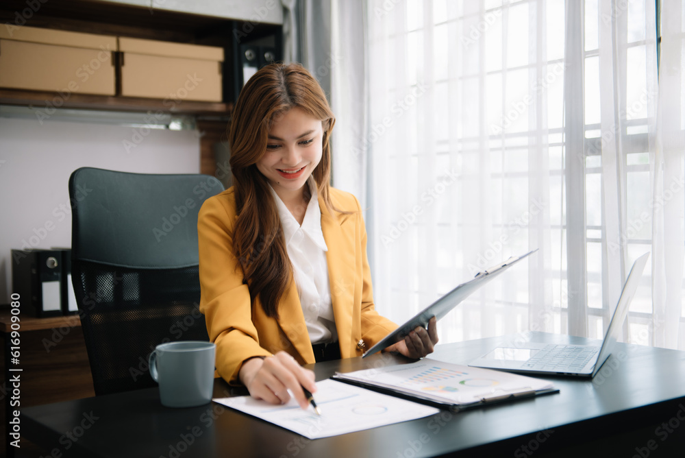Young beautiful woman typing on tablet and laptop while sitting at the working wooden table office. Young beautiful woman typing on tablet and laptop while sitting at the working wooden table office.