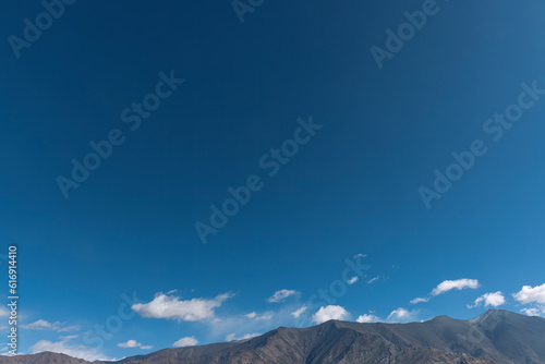The deep blue natural sky and the towering peaks of distant mountains serve as an awe-inspiring backdrop