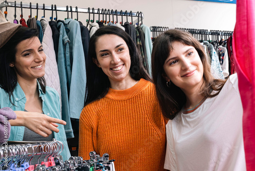 Smiling friends shopping in clothes showroom