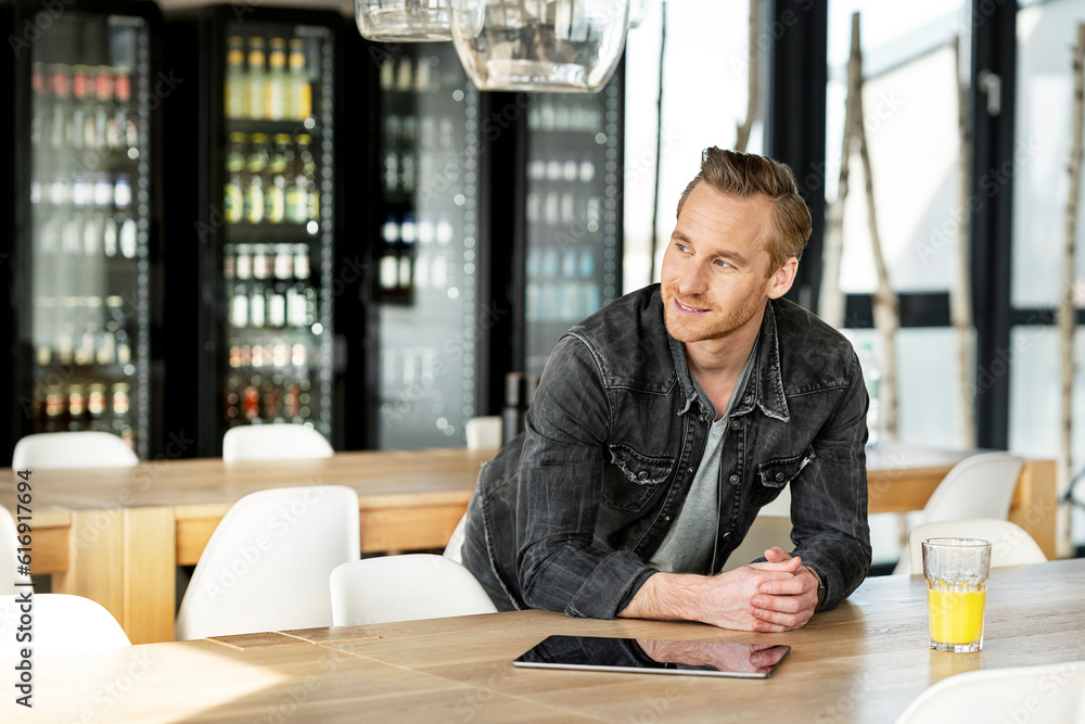 Happy businessman leaning on table in cafeteria Happy businessman leaning on table in cafeteria