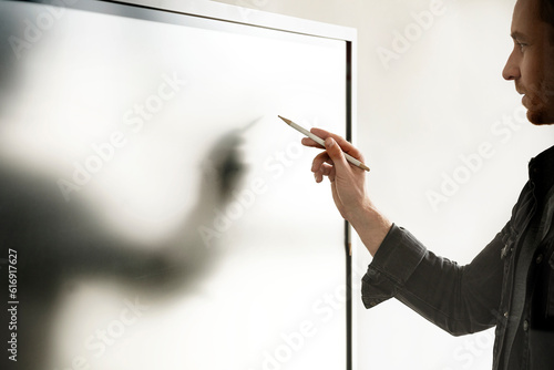 Businessman with digitized pen writing on interactive whiteboard photo