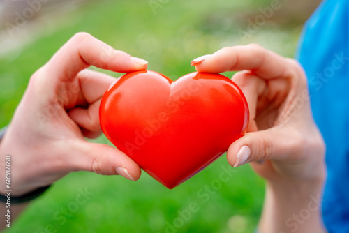 Couple holding red heart.Getting together in love concept