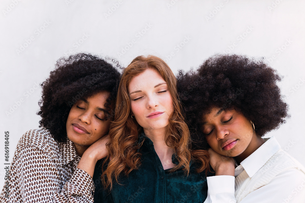 Businesswoman with eyes closed in front of wall Businesswoman with eyes closed in front of wall