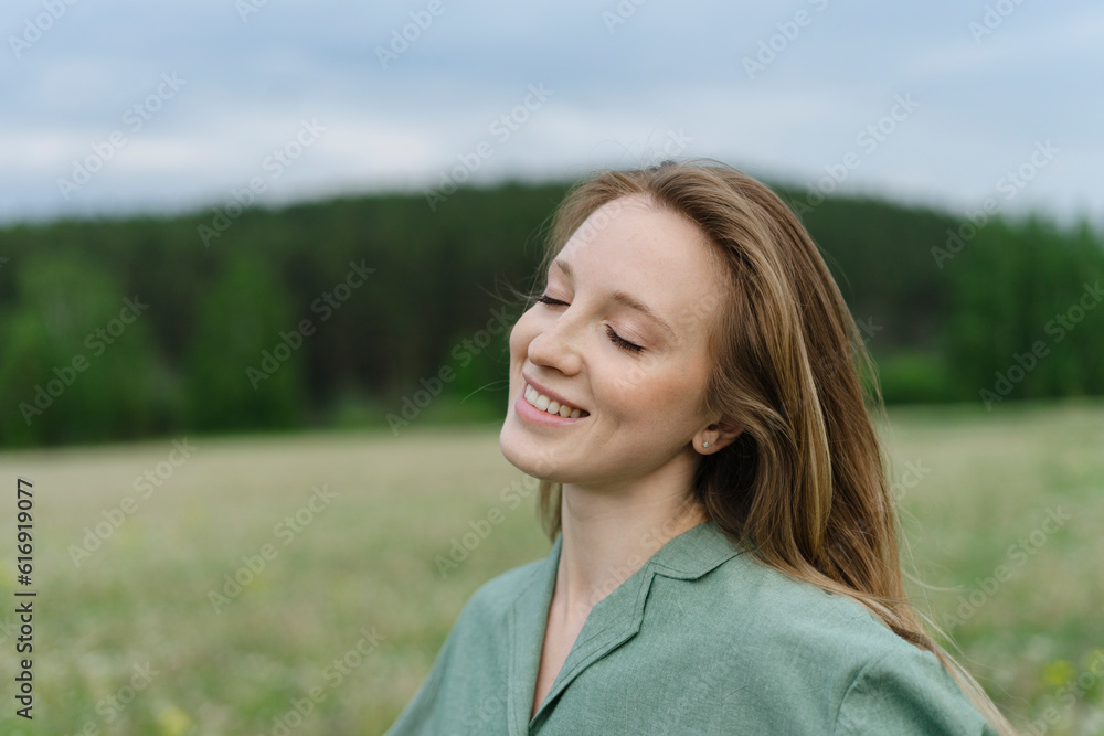 Smiling young woman with eyes closed on field Smiling young woman with eyes closed on field