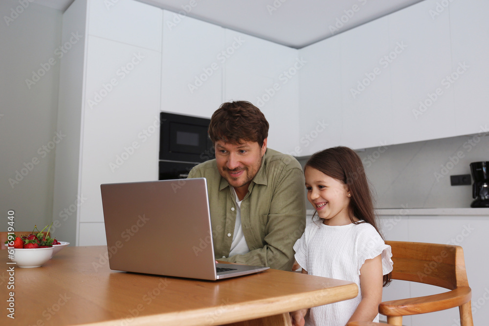 Smiling man teaching laptop to daughter at home Smiling man teaching laptop to daughter at home