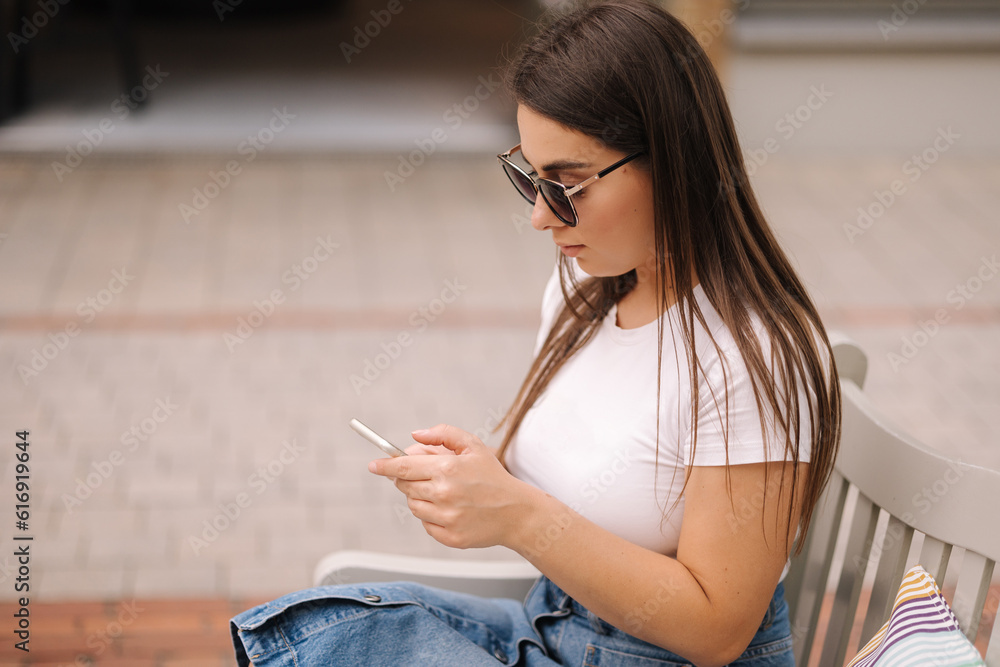 Side view of female ssm manager configures the target on her phone. Woman working outdoors Side view of female ssm manager configures the target on her phone. Woman working outdoors